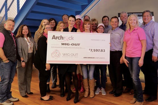 Team holding large donation check