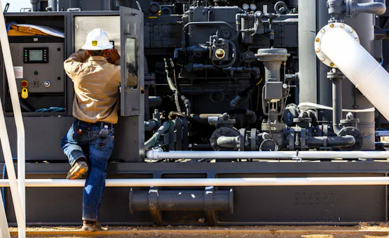 Archrock employee facing compressor..